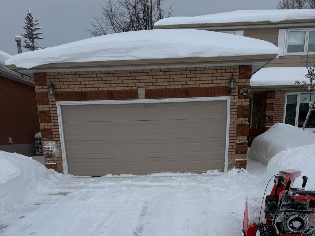 Snow removal service clearing a residential driveway in Simcoe County