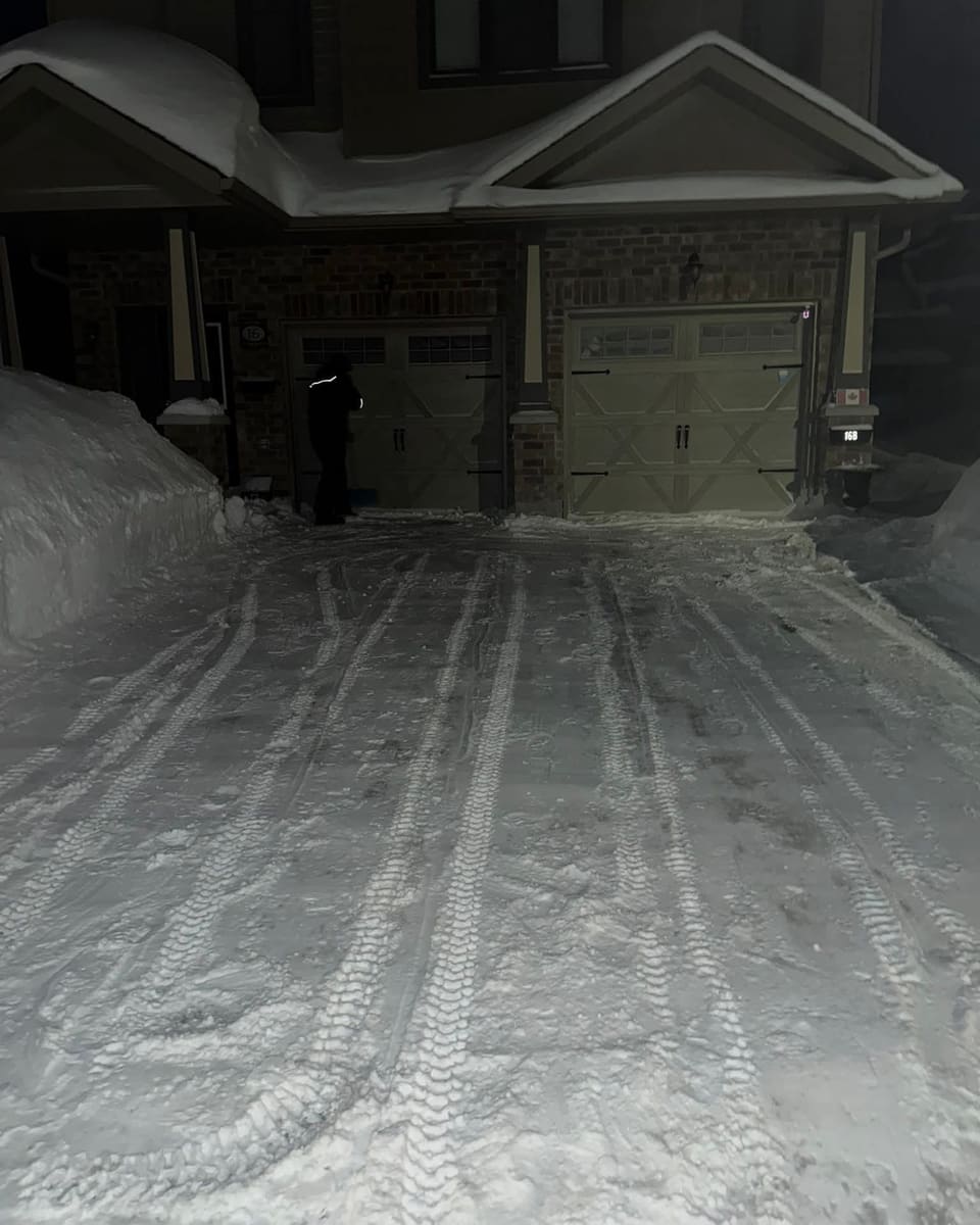 Townhouse driveway and walkway cleared of snow at night in Orillia area